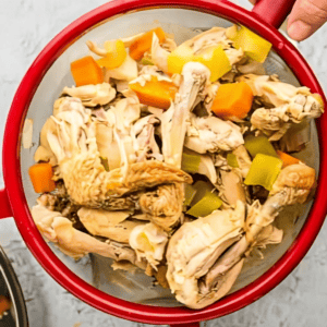 straining the meat out of chicken stock.