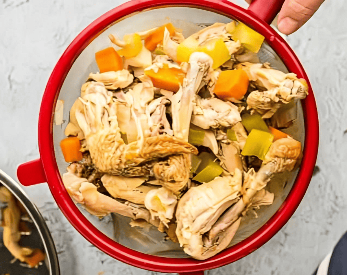 straining the meat out of chicken stock.