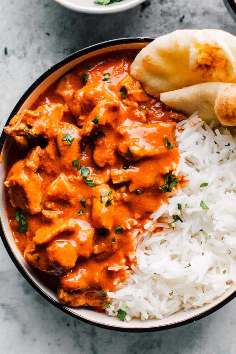 bowl of instant pot butter chicken with rice and naan
