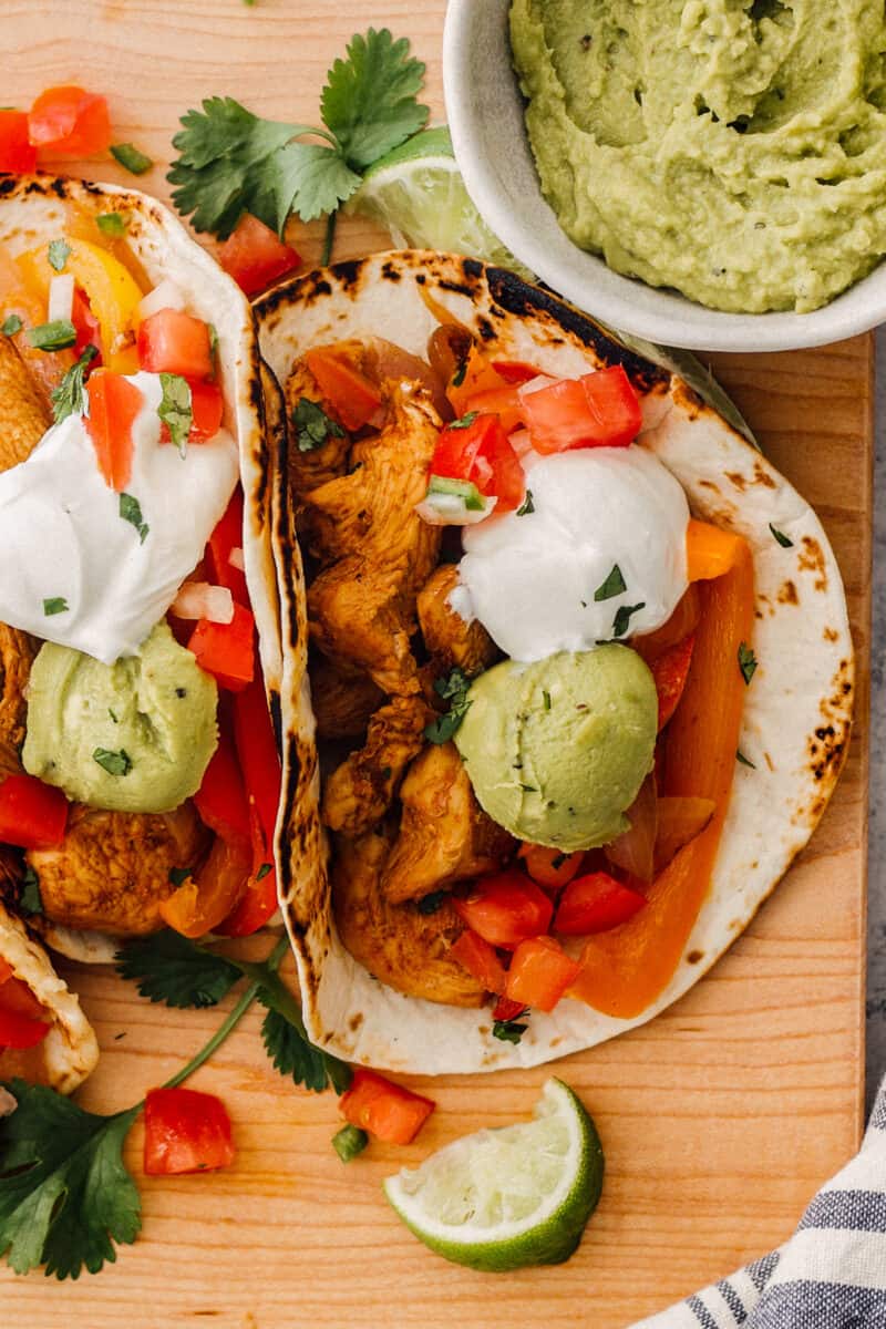 up close instant pot chicken fajitas in tortillas and garnished
