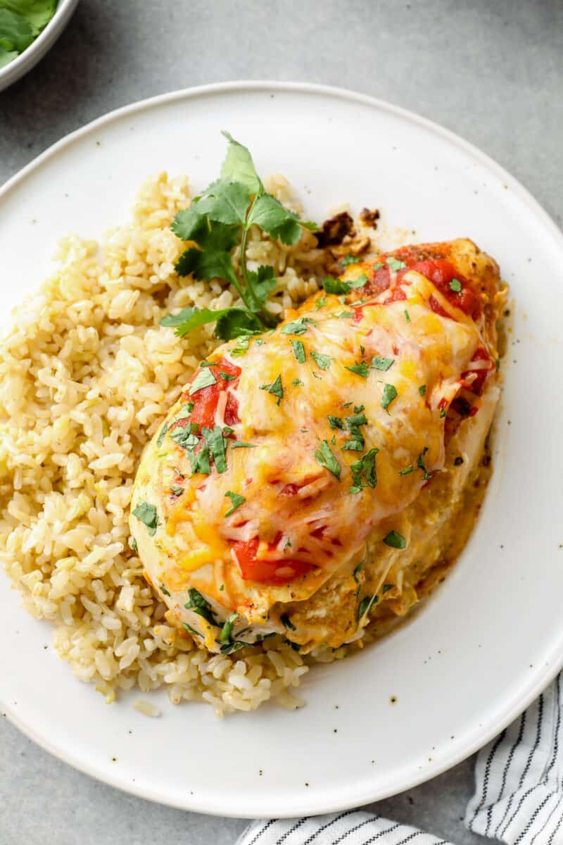 taco stuffed chicken served over rice on white plate