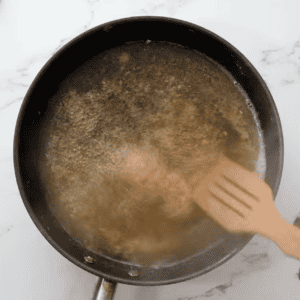 deglazing a pan with marsala wine and a wooden spatula.