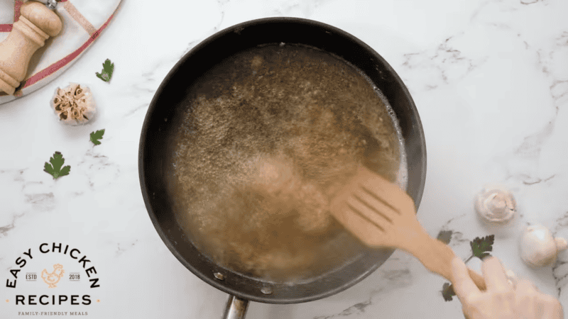 deglazing a pan with marsala wine and a wooden spatula.