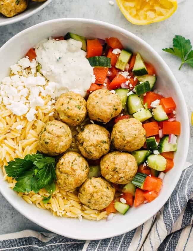 Greek chicken meatballs over veggies, rice and tzatziki sauce