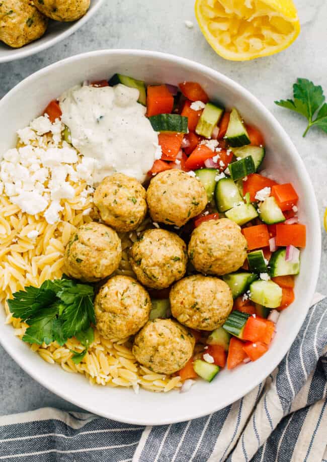 Greek chicken meatballs over veggies, rice and tzatziki sauce