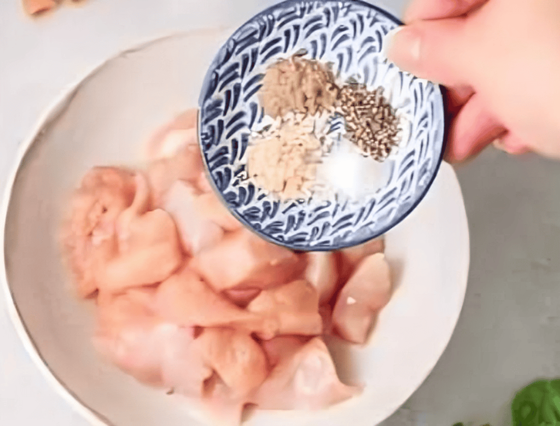 seasoning cubed chicken breasts with spices.