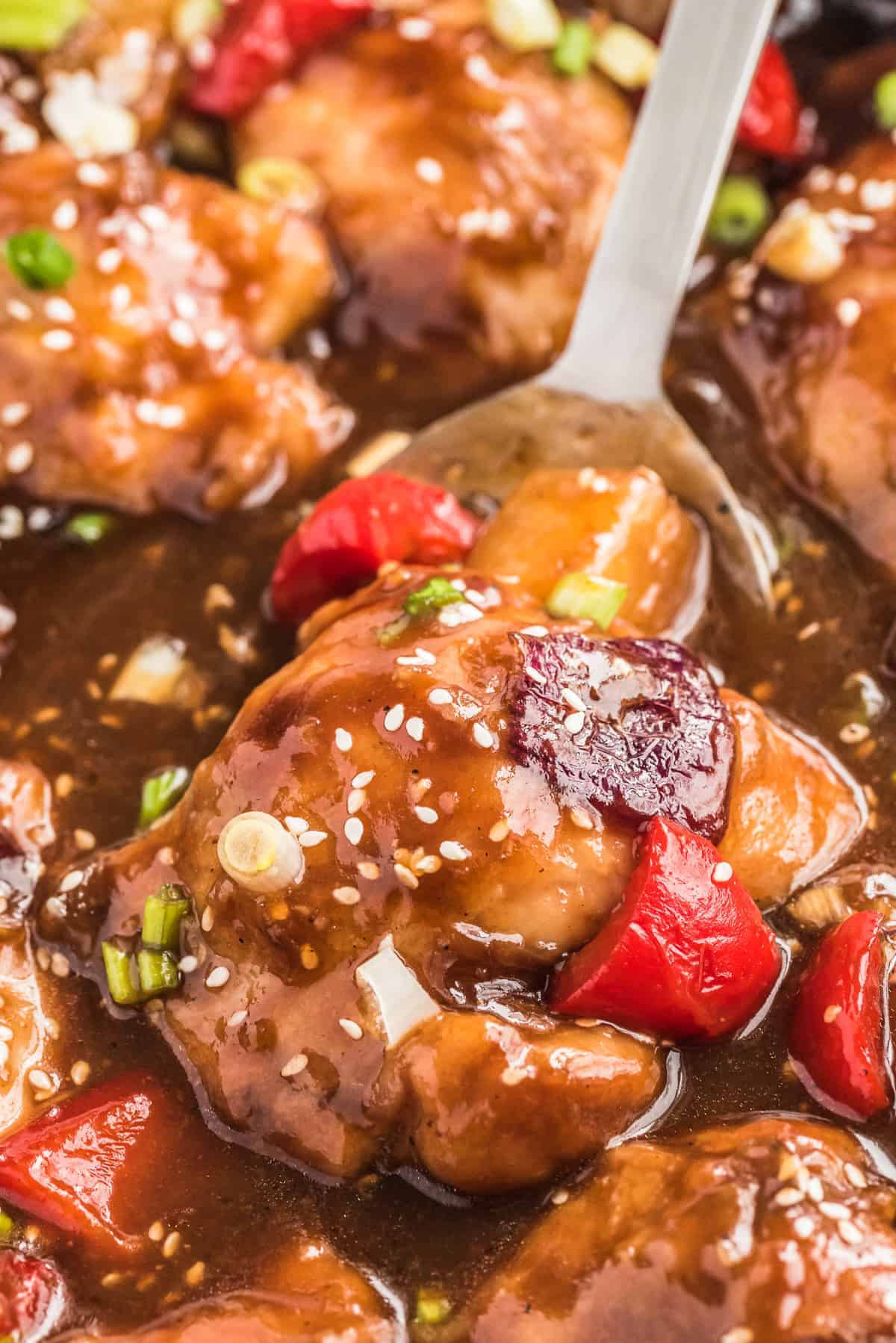 Spoon scooping up a portion of Hawaiian chicken.