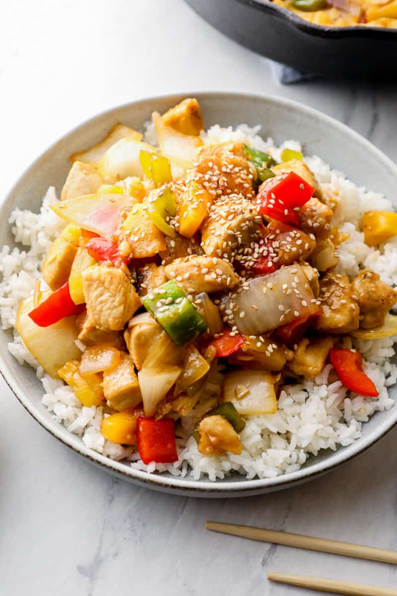 sweet and sour chicken over white rice on gray plate