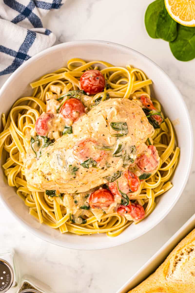 tuscan chicken in bowl over pasta