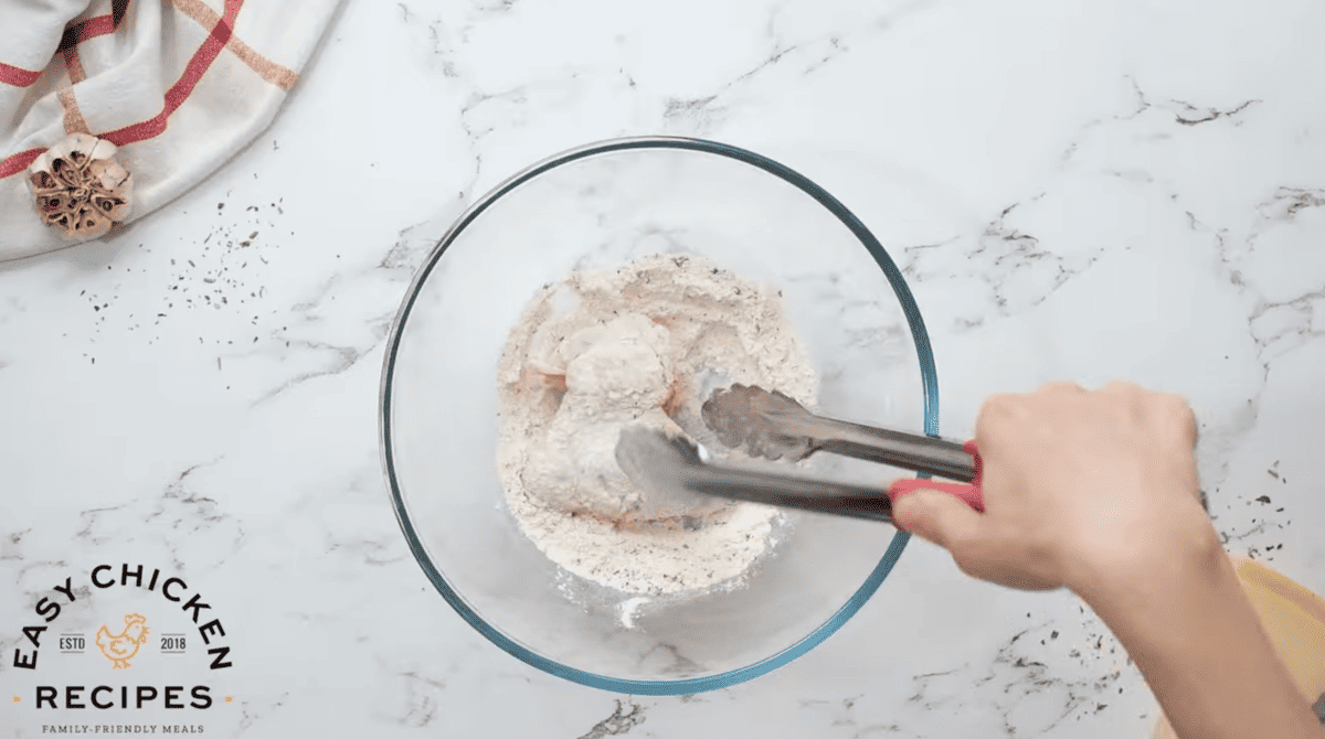 Wings are being coated in seasoned flour.