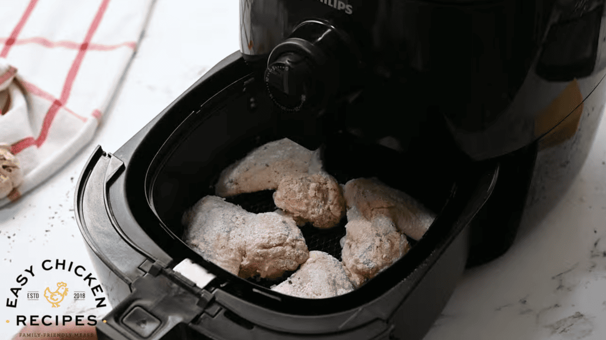 Uncooked chicken is being placed in the air fryer.