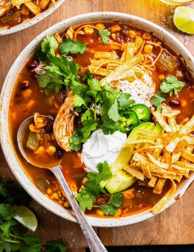 overhead view of crockpot chicken tortilla soup in a bowl with a spoon.