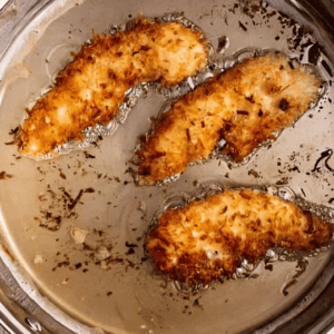 fried coconut chicken tenders in oil.