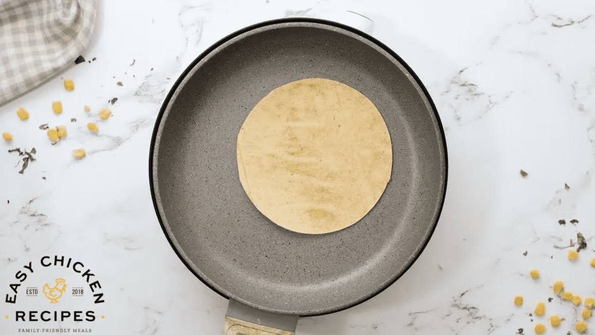 A tortilla is being warmed in a pan. 