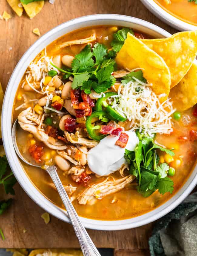 overhead view of a bowl of bacon chicken chili with a spoon.