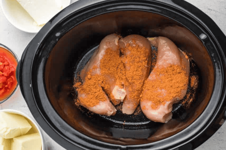 Chicken breasts with taco seasoning in a crockpot.