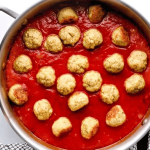 chicken meatballs in tomato sauce in a saucepan.