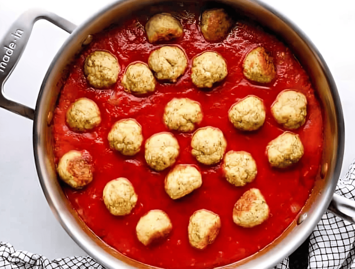 chicken meatballs in spaghetti sauce in a saucepan.