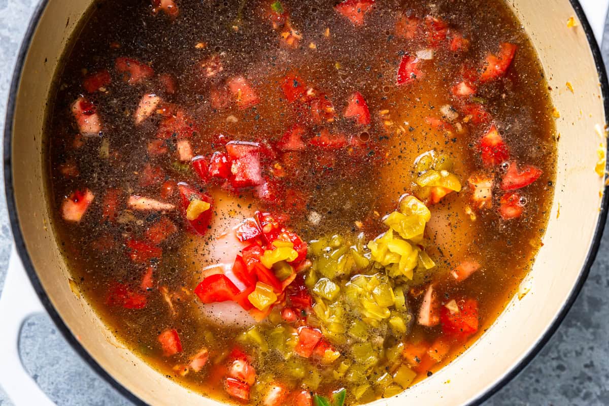 chicken, tomatoes, and other chili ingredients in a large pot.