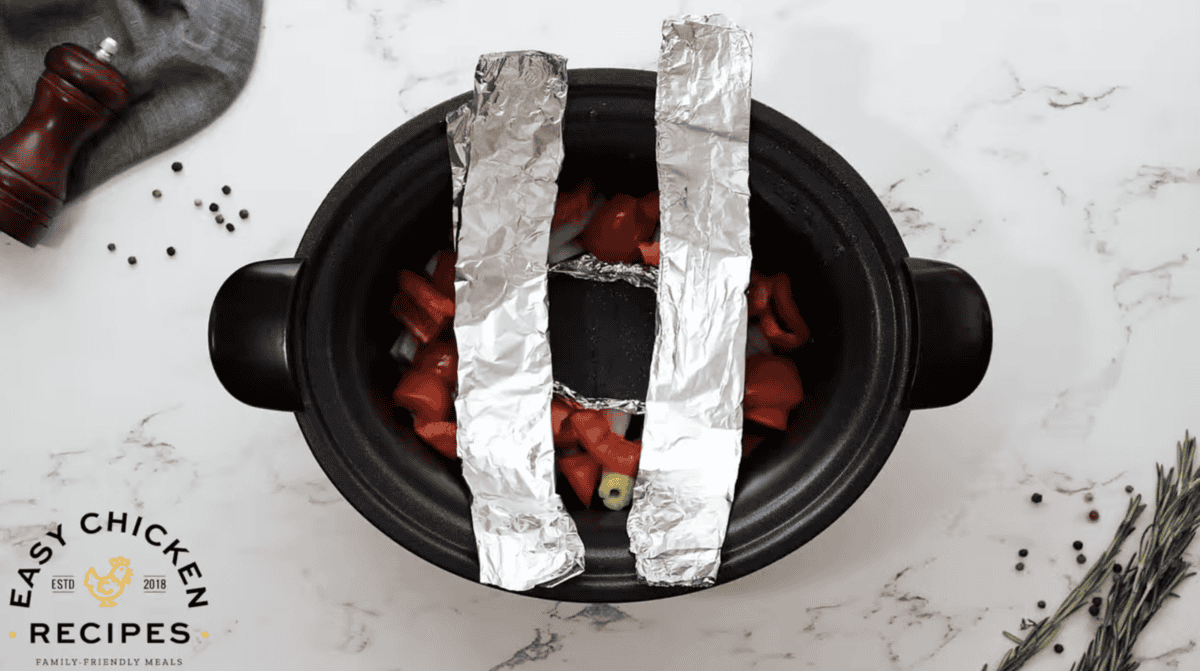 Veggies and foil are in a Crockpot. 