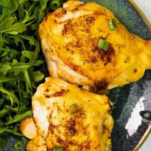 up close air fryer ranch chicken thighs on blue plate with salad