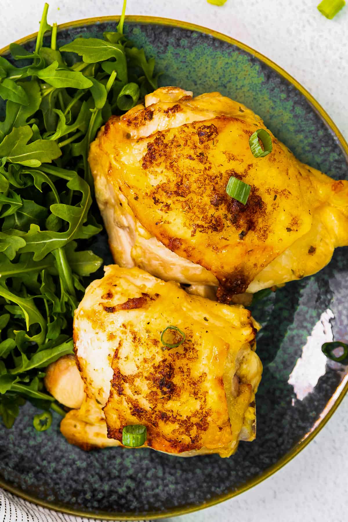 up close air fryer ranch chicken thighs on blue plate with salad