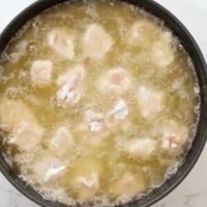 frying breaded chicken pieces in oil.
