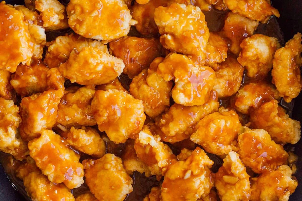 closeup of crispy sauced orange chicken pieces.