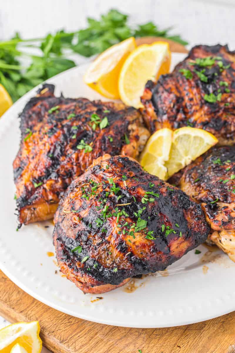 4 marinated grilled chicken thighs on white platter