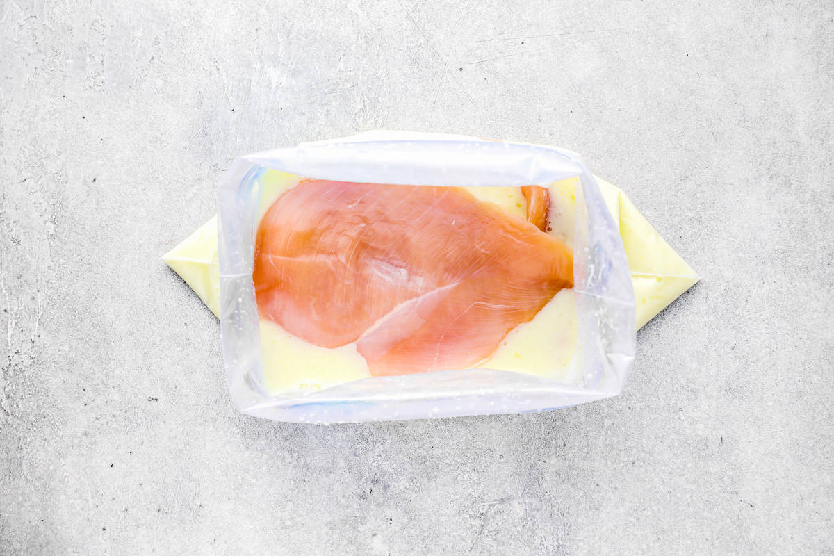 a chicken breast in a bag fulled with milk, pickle juice, and lemon juice.
