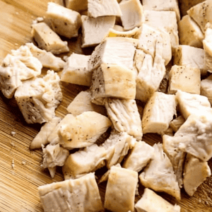 chopped cooked chicken breast on a cutting board.