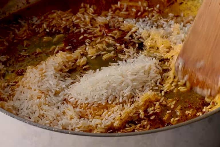 Rice sauteing for spanish chicken and rice in a skillet