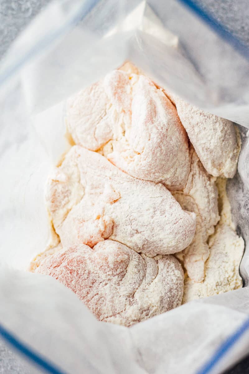 flour coated chicken in bag