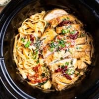 overhead view of sliced tuscan chicken and pasta in a crockpot.