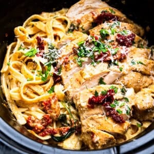 sliced tuscan chicken and pasta in a crockpot.