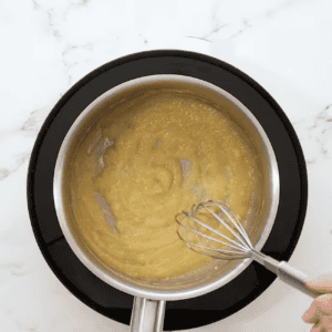 making a roux in a saucepan with a whisk.