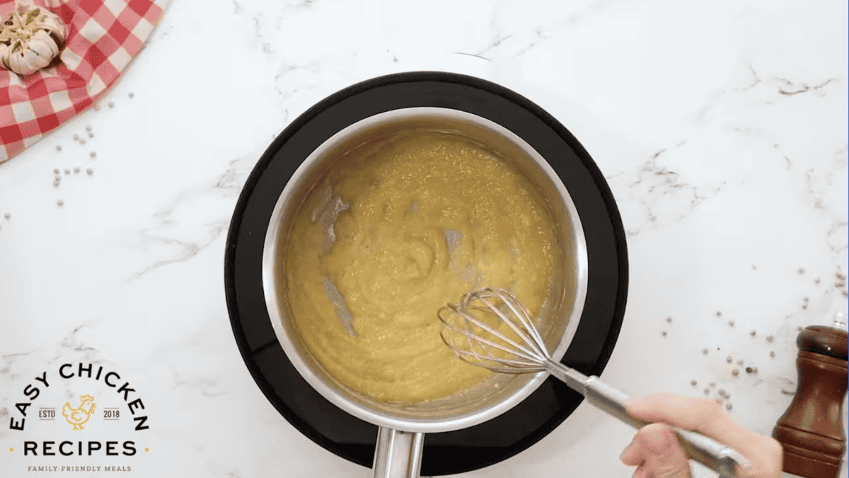 making a roux in a saucepan with a whisk.