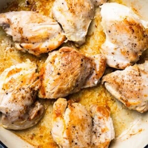 seared chicken thighs in a brasier.