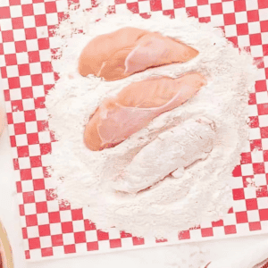 coating chicken tenders in flour.