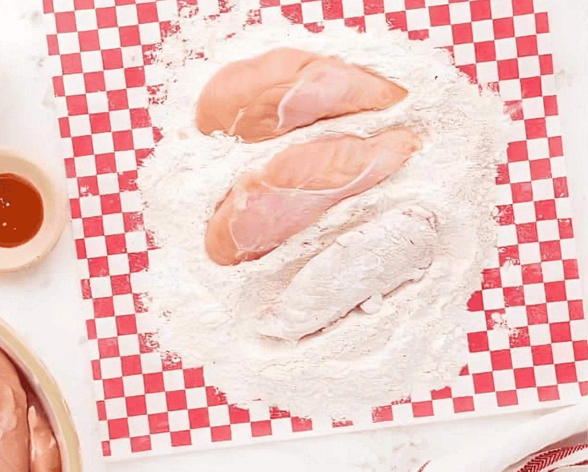 coating chicken tenders in flour.