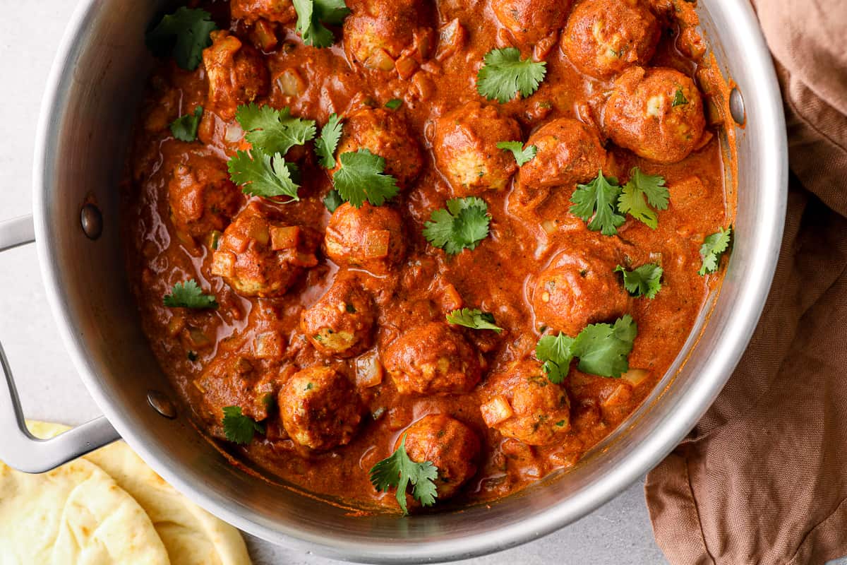 Indian butter chicken meatballs in a pan topped with cilantro.