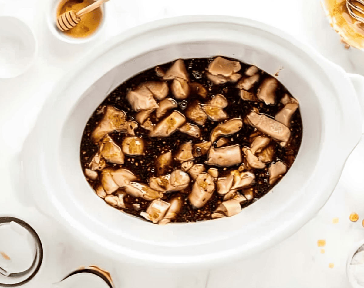 sesame sauce over raw chicken chunks in a slow cooker.