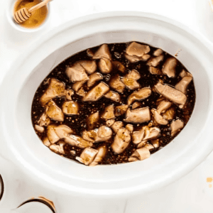 sesame sauce over raw chicken chunks in a slow cooker.