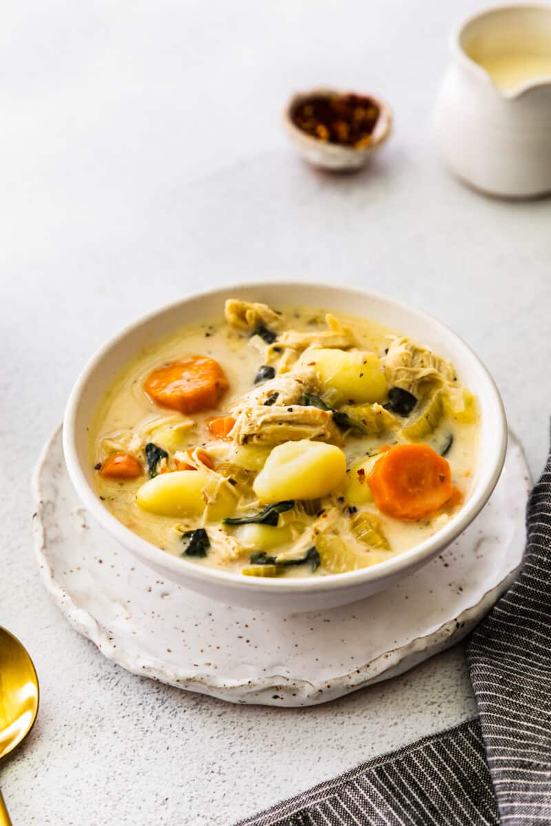 chicken gnocchi soup in a white bowl on a plate