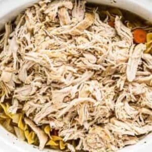 Shredded chicken added to crockpot chicken noodle soup.