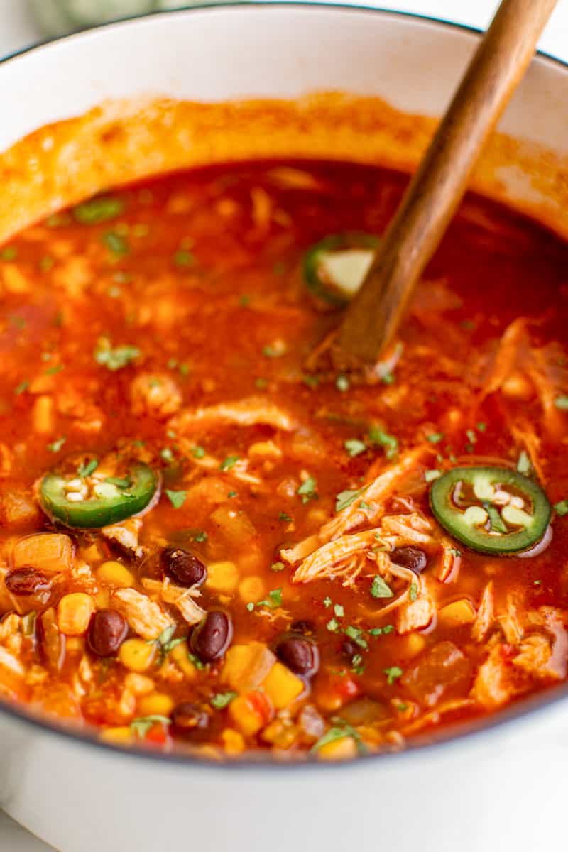 chicken taco soup in a white pot with a wooden spoon