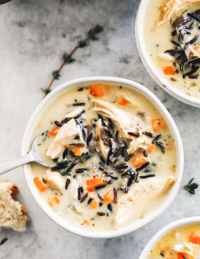 overhead image of chicken wild rice soup in a white bowl with a spoon