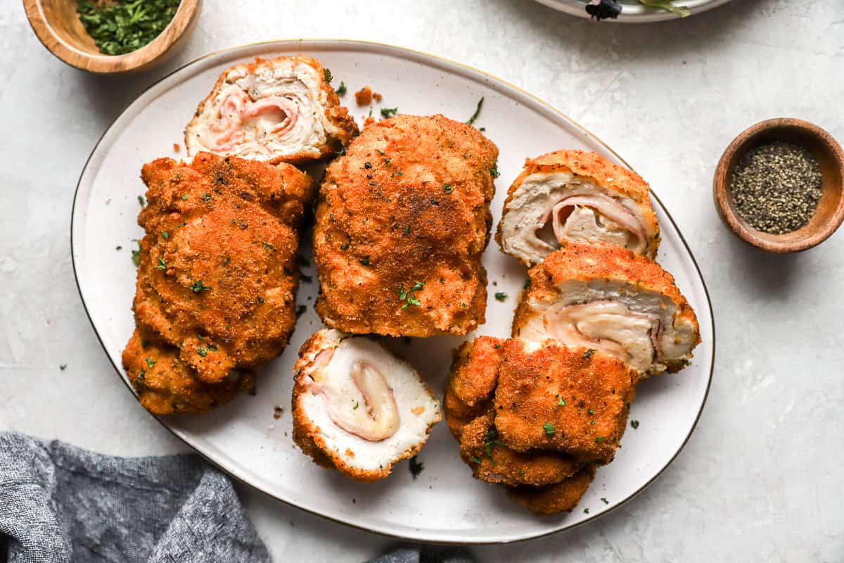 overhead view of sliced servings of chicken cordon bleu on a white oval serving dish.