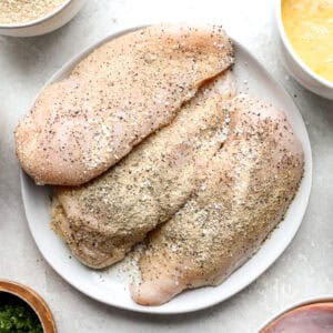 seasoned chicken breasts on a white plate.