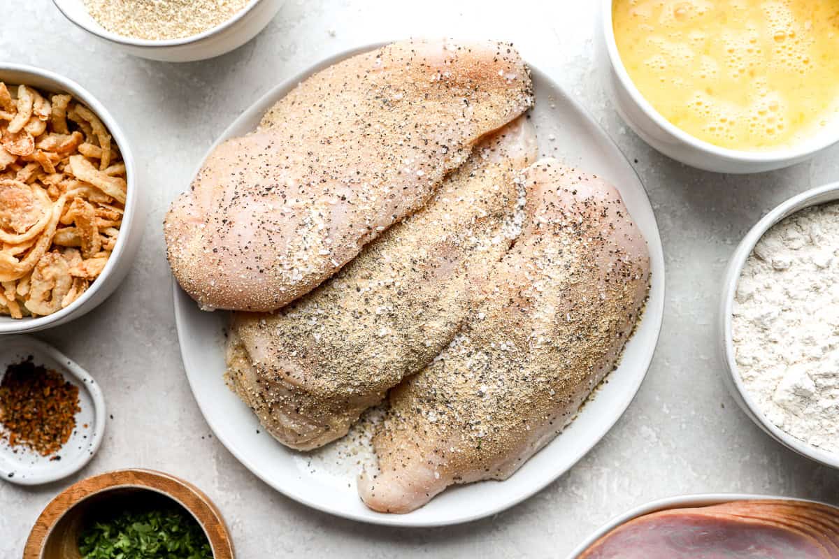 seasoned chicken breasts on a white plate.